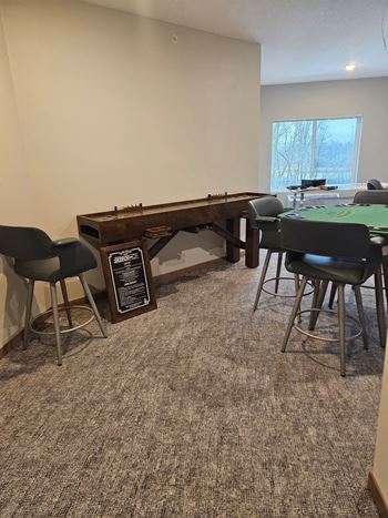 A room with a carpeted floor and a pool table.